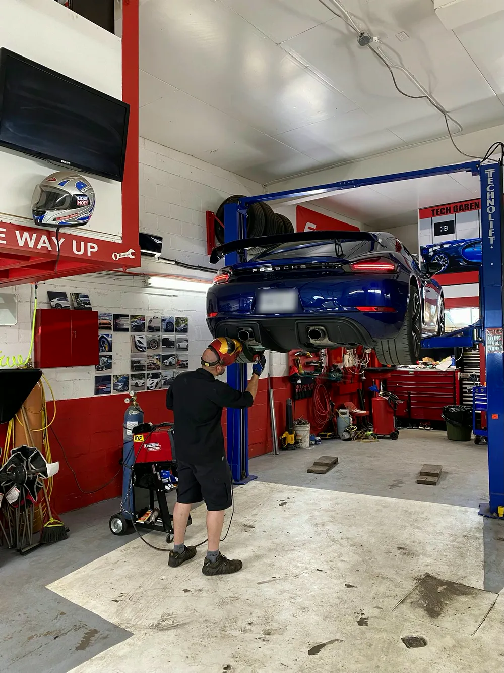 Travail d'échappement sous une Porsche sur le lift